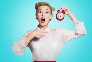 woman holding red alarm clock pointing at it surprised helping you master the quickie concept